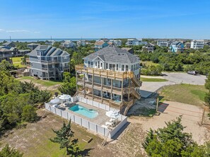 A multi-story house with a pool, surrounded by a fence, and a view of the ocean. - Saltwater Pool | Hot Tub | Elevator | Rec Room (Salvo)
