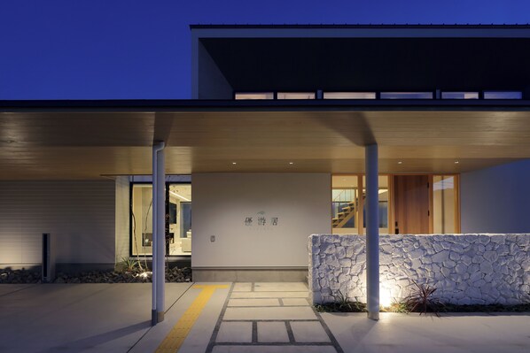 A modern building with a stone wall and a covered entrance. - MOKU AMANOHASHIDATE YUYUKYO (Miyazu)