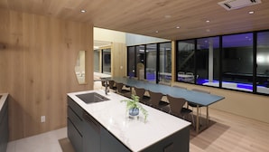 A modern kitchen with a marble countertop, wooden cabinets, and a large island.