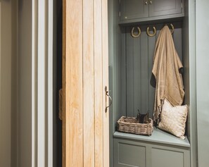 A wooden wardrobe with a hanging coat rack and a basket. - Luxurious Cotswolds Apartment in Chipping Campden (Chipping Campden)