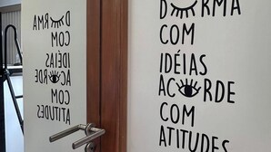 Uma porta com uma placa que diz 'DREAMS COM IDEIAS ACORDE COM ATITUDES'.