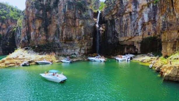 A river with boats and a waterfall. - Light and comfort in Passos, 40 minutes from Capitólio. (Passos)