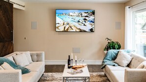 Ein Wohnzimmer mit zwei Sofas, einem Couchtisch mit Flasche und Gläsern sowie einem Bild an der Wand.