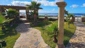 A stone pathway leading to a covered area with a view of the ocean. - Casa del mar beach resort (Salsipuedes)