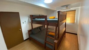 Quarto com beliche, escada, porta e janela com persianas.