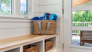 A room with a wooden bench, wicker baskets, and a woven basket with towels. - Private Pool + Backyard + Steps to the Beach (Cocoa Beach)