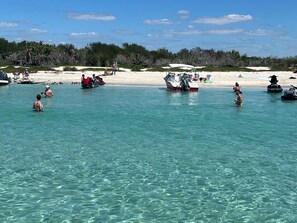A beach with clear turquoise water, boats, and people. - Waterfront Siesta Key • Community Dock • Near Beach & Dining • 30 Night Minimum (Sarasota)