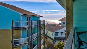A multi-story building with balconies, a view of the ocean, and a clear sky. - High Tide @ Island North - 3 Bedroom Condo with Community Pool (Carolina Beach)