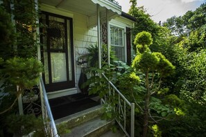 Una casa con porche, escalones y jardín.