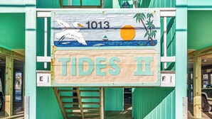 En träskylt med texten ”1013 TIDES II” och en illustration av en mås, som visar platsen för en viss verksamhet eller ett visst ställe.