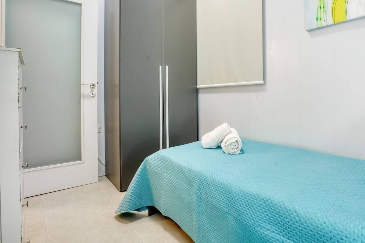 Une chambre à coucher avec un lit, une porte et une œuvre d’art accrochée au mur.