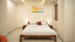 Ein Schlafzimmer mit einem Bett, zwei Nachttischen mit Lampen, einem Deckenventilator und einem Bild an der Wand.