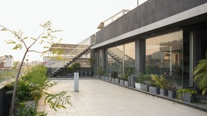 Ein modernes Gebäude mit großen Fenstern, einer Treppe und Topfpflanzen.