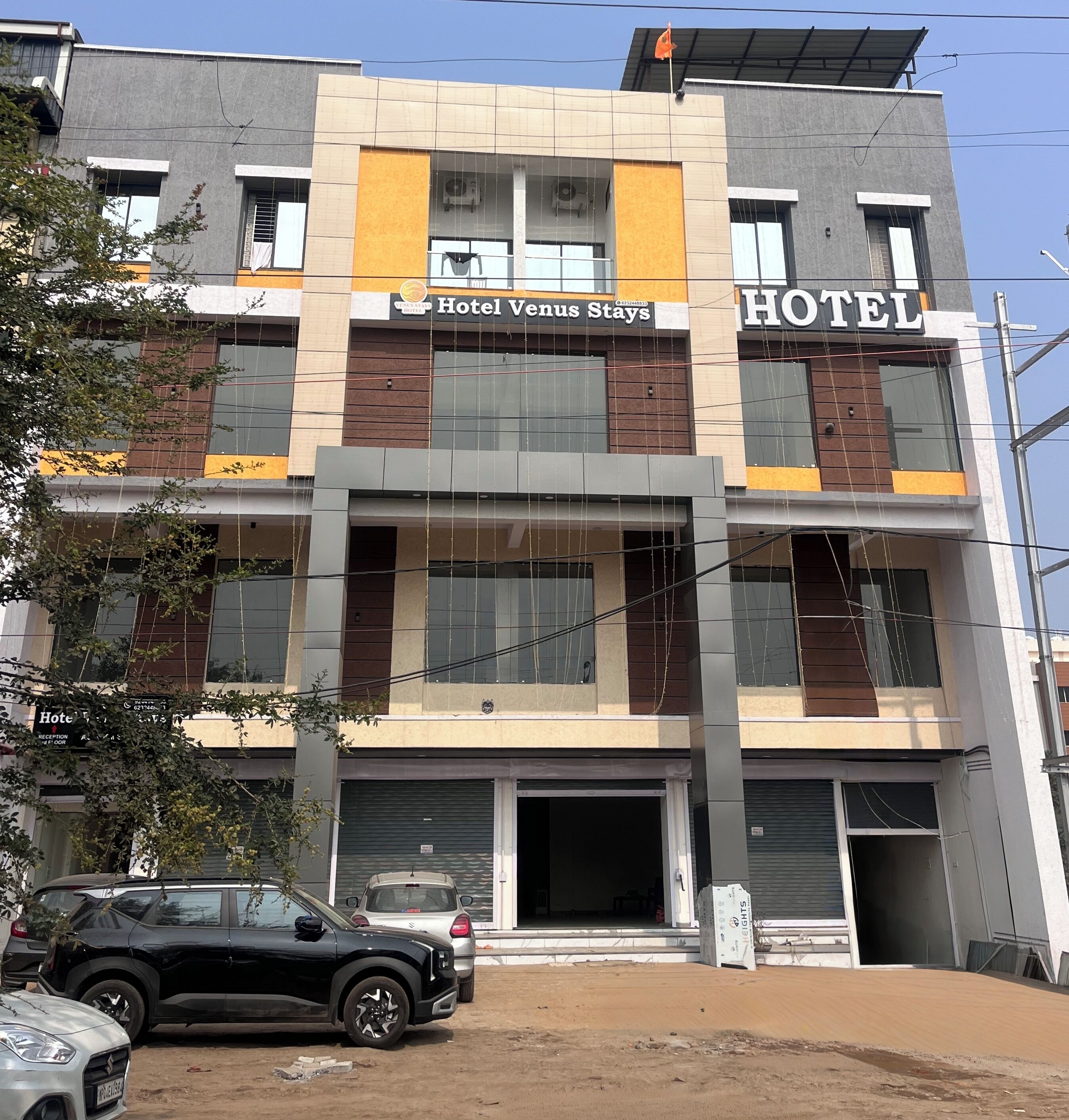 Un edificio de hotel de varios pisos con un diseño moderno, que cuenta con una zona de recepción y una entrada visible.