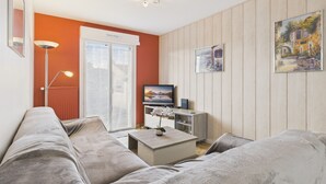 Un salon moderne comprenant un canapé, une table basse, un téléviseur et un meuble.
