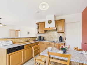 A kitchen with wooden cabinets, a granite countertop, a built-in dishwasher, and a coffee maker. - House for 4 · garden · heart of Les Sables (Les Sables-d´Olonne)