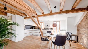 A spacious dining area with a wooden ceiling, a round table, and black chairs. - Alte Schule Tiefenbach  (Östringen)