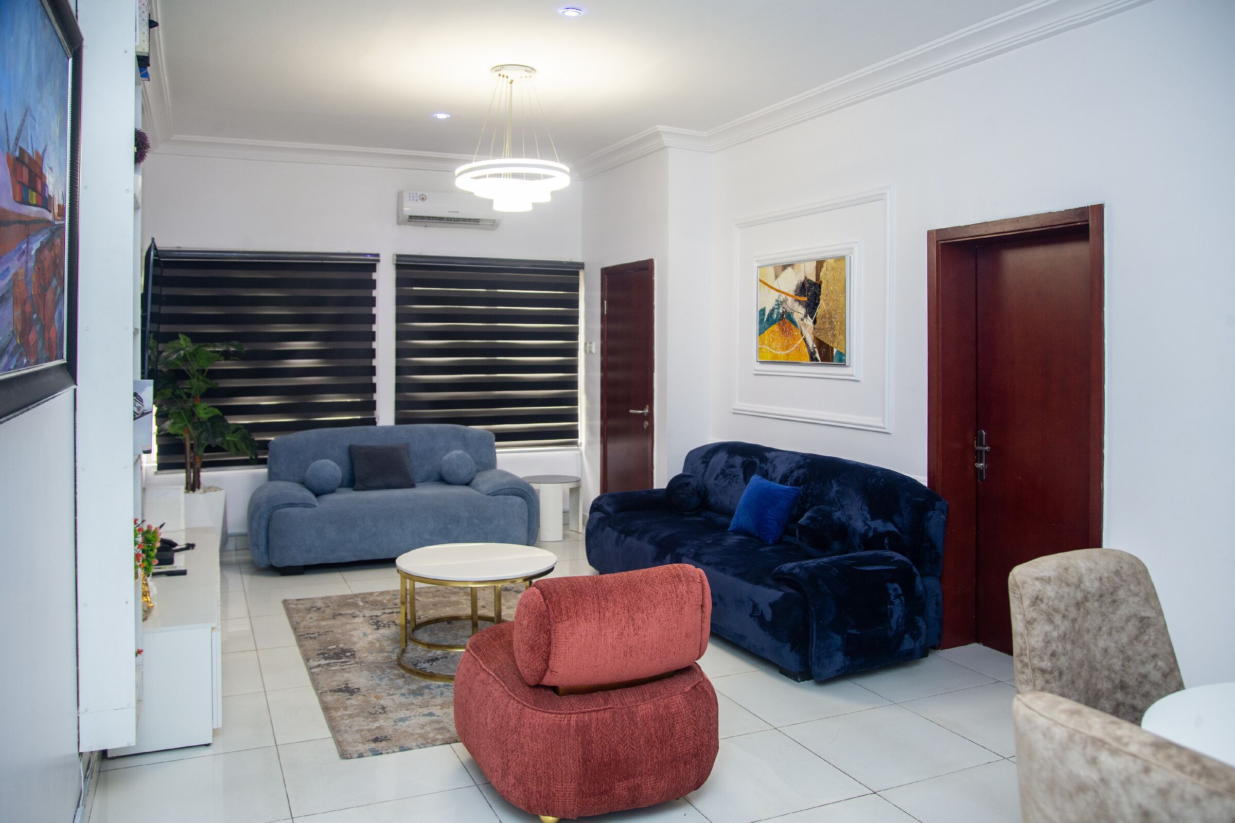 Ein modernes Wohnzimmer mit zwei Sofas, einem Couchtisch und einem roten Sessel.