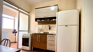 A compact kitchen with a stove, oven, and a refrigerator. - Residencial Liberdade (São Paulo)
