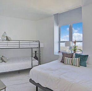 Ein Zimmer mit Etagenbett, Einzelbett und Fenster mit Blick.