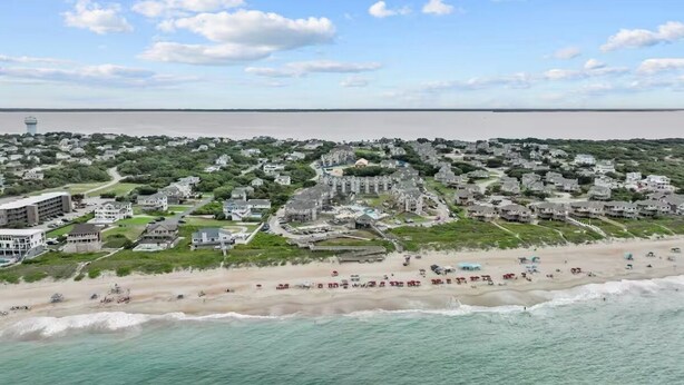 A coastal town with a beachfront, residential buildings, and a water tower. - BIS-Duck - 2BR/2BA - Great Pools & Beach! (Duck)