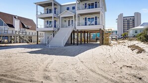 A multi-story beachfront building with balconies, a staircase, and a sandy beach area. - Private Pool Rooftop Deck w/ Panoramic Views It's A Shore Thang (Navarre)