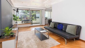 Una sala de estar moderna con sofá, mesa de centro y televisor.