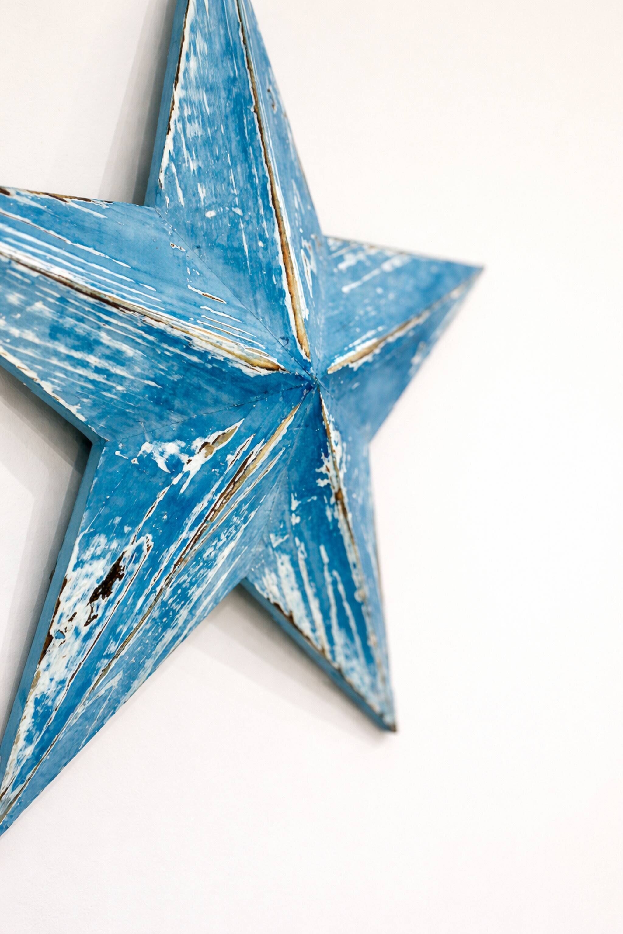 A star-shaped object with a distressed blue paint finish.