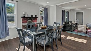 Un espace de vie moderne comprenant un coin repas, une cheminée et un coin salon confortable.