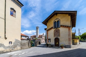 Une rue bordée d’immeubles, dont une église dotée d’un clocher et un bâtiment avec une grande fenêtre en arc de cercle.