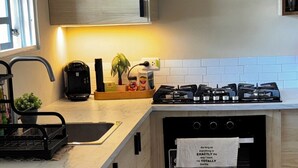 Eine moderne Küche mit Holzausstattung, einem Backofen, einem Geschirrspüler und einer Kaffeemaschine.