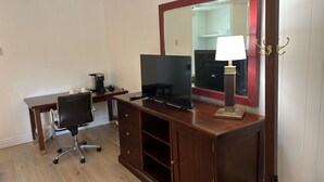 A room with a wooden desk, a black office chair, a flat-screen TV, a coffee maker, a lamp, and a mirror. - Seeleys Bay Motel and Resort (Seeleys Bay)