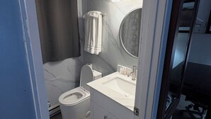 A modern bathroom with a toilet, sink, and shower. - Seeleys Bay Motel and Resort (Seeleys Bay)