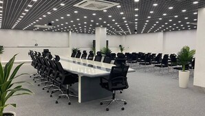 A conference room with a long table, black chairs, and potted plants. - Rauza Hotel Tashkent (Tashkent)