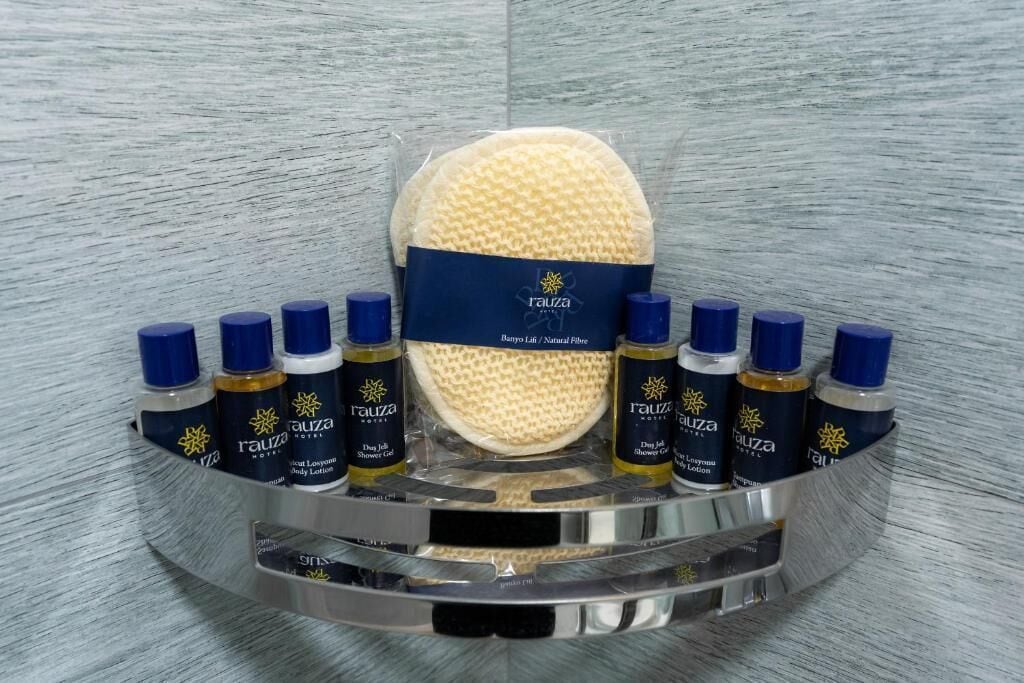 Un meuble-lavabo de salle de bain avec une grande éponge de bain beige, un distributeur de savon bleu et un flacon de lotion pour le corps.
