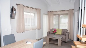 A modern living room with a dining table, sofa, and a coffee table with flowers. - Sea View Frini- Lefkada (Lefkada)