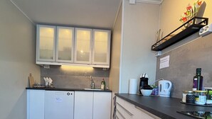 Une cuisine moderne avec des meubles blancs, un plan de travail noir et un tapis à motifs.