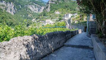 Un sendero de piedra que conduce a un pueblo en la ladera, con edificios y vegetación.