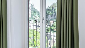 A window with a view of a mountainous landscape and buildings. - Villa Zagara (Amalfi)