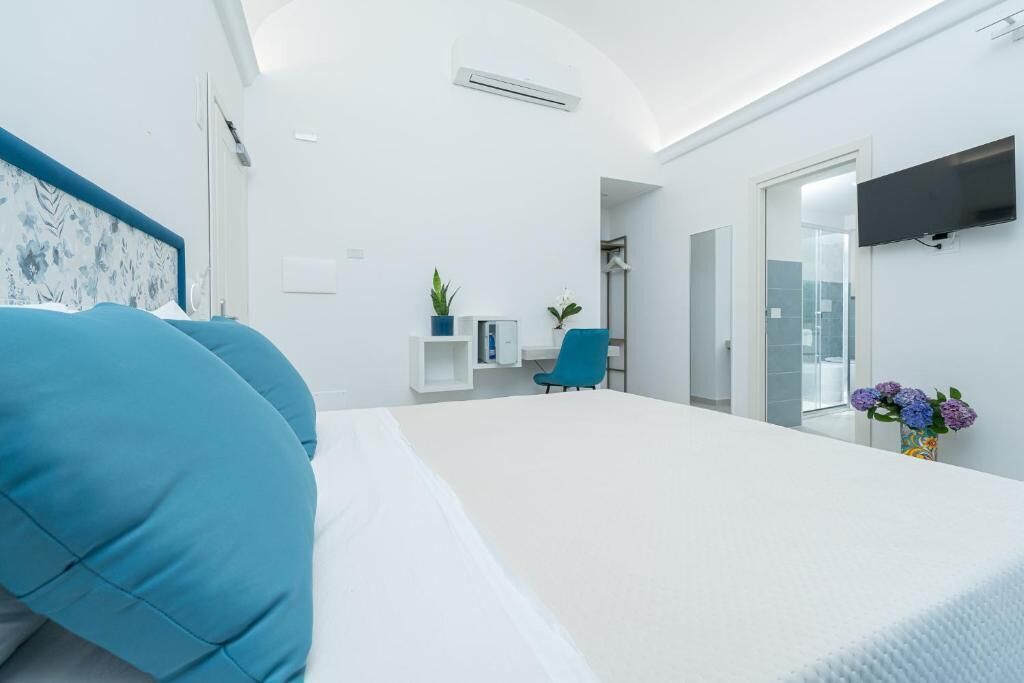Une chambre moderne avec un grand lit, un bureau et une télévision.