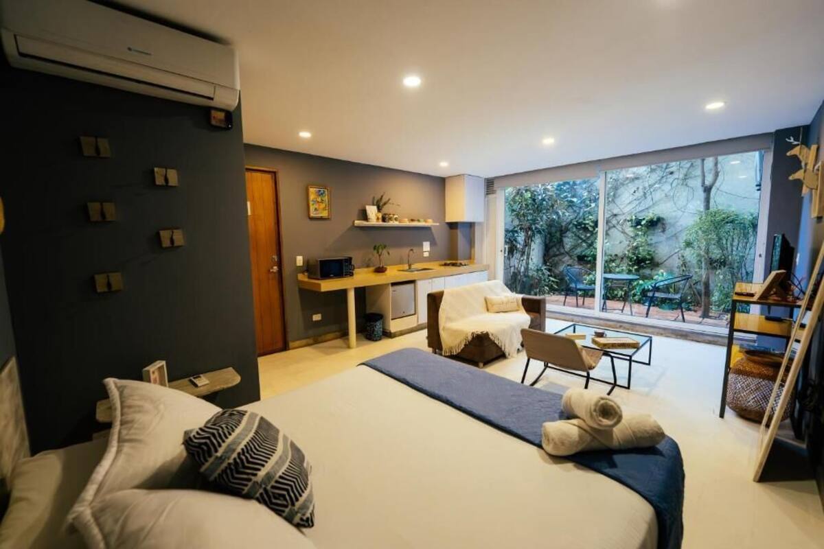 Un dormitorio moderno con una cama grande, un escritorio y vistas al exterior.