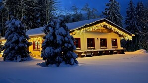 Eine schneebedeckte Holzhütte mit einem Schild, auf dem "Innneck Alm" steht.