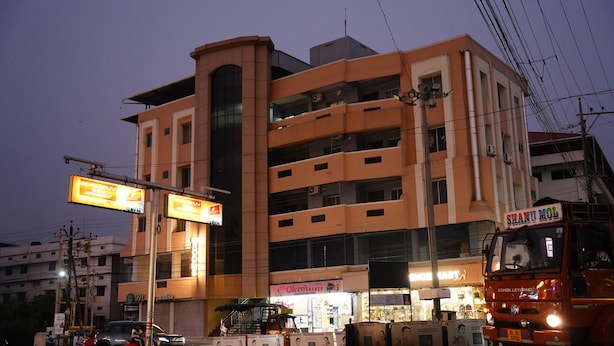 A multi-story building with commercial signage, including a hypermarket and a bakery. - Stay Ease Rental Rooms (Palakkad)