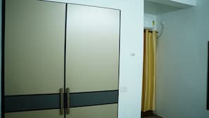 A room with a wardrobe, a shower curtain, and a light switch. - Stay Ease Rental Rooms (Palakkad)