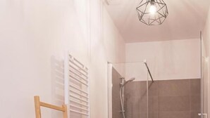 Ein Badezimmer mit einem Holzbett mit zwei Etagen, einer Dusche und einer Toilette.