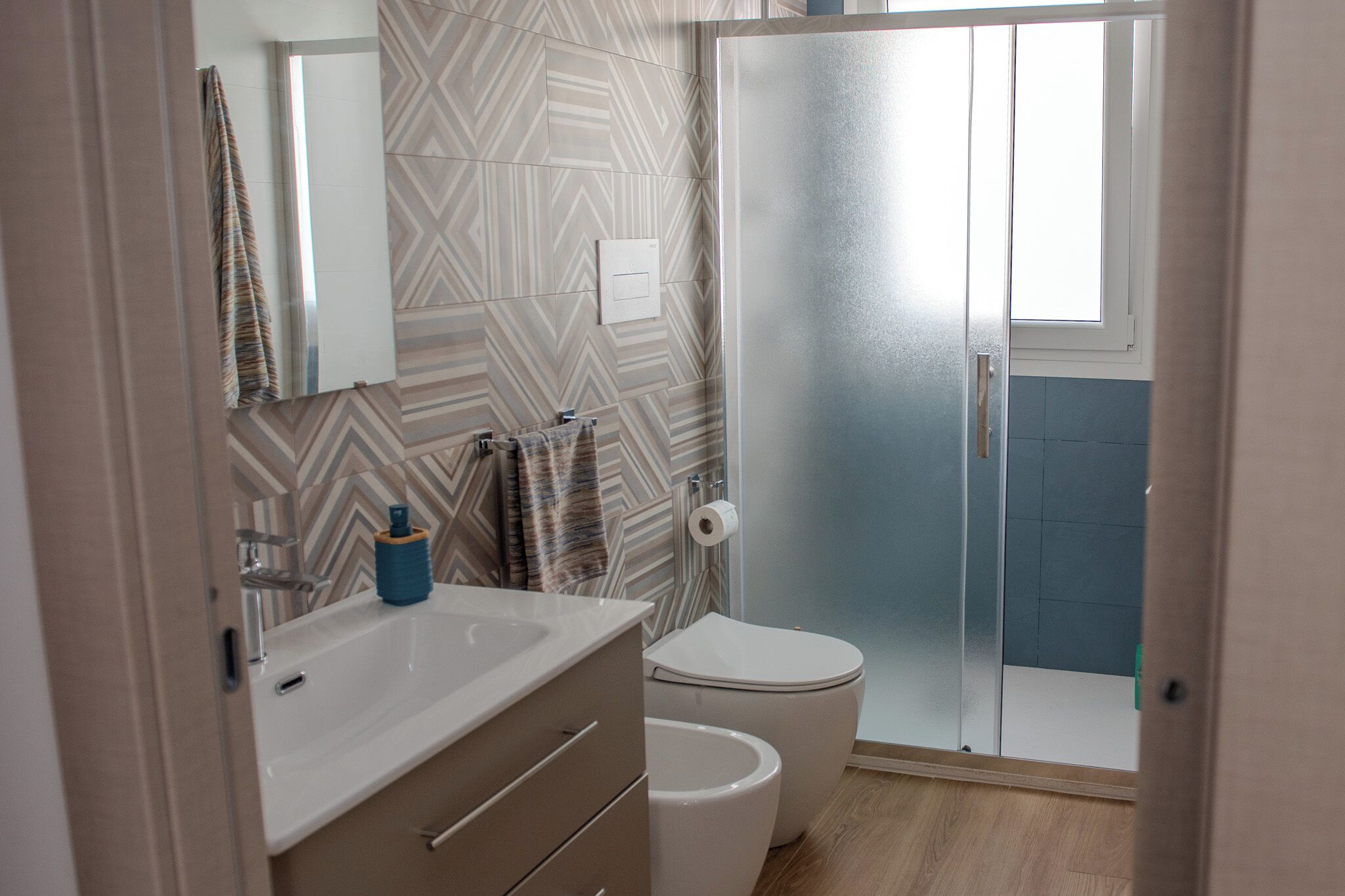 Une salle de bain avec un lavabo blanc, des toilettes et un espace douche.