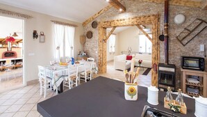 A cozy living room with a fireplace, a dining area, and a kitchen. - Villetta Tra Mari E Monti (San Giovanni Rotondo)