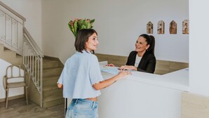 Un espace d’accueil comprenant un escalier, un comptoir de réception et un mur agrémenté d’éléments décoratifs.