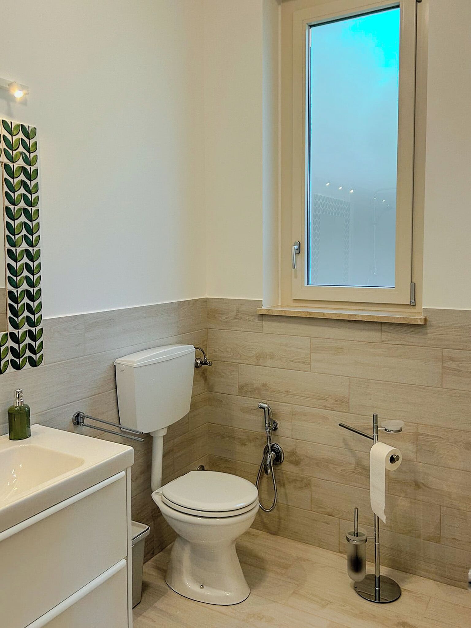 A modern bathroom with a toilet, sink, and shower.