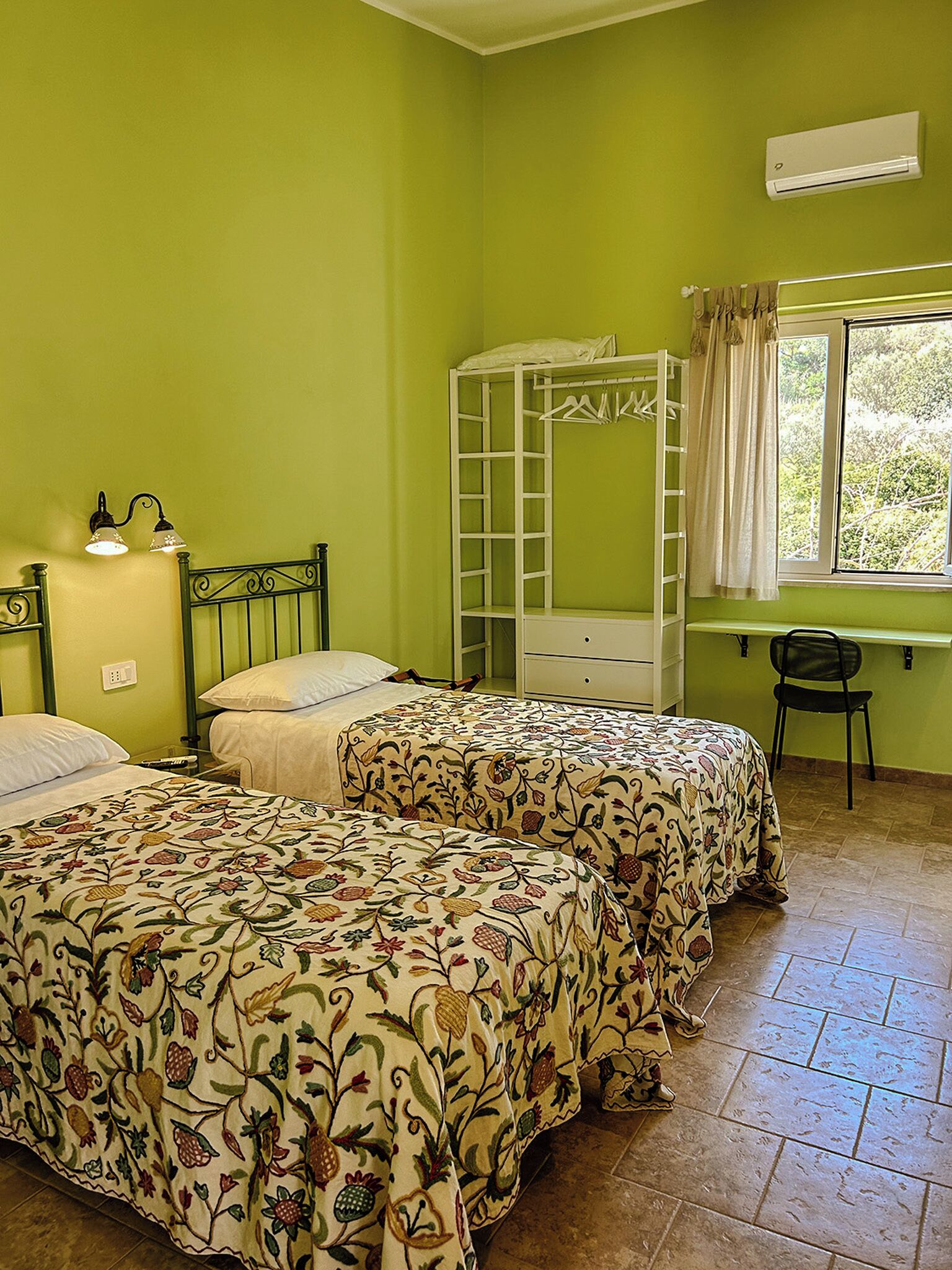 A room with two beds, a desk, and a chair.